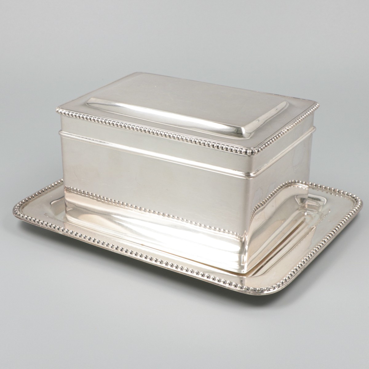 Koektrommel met onderschotel zilver.