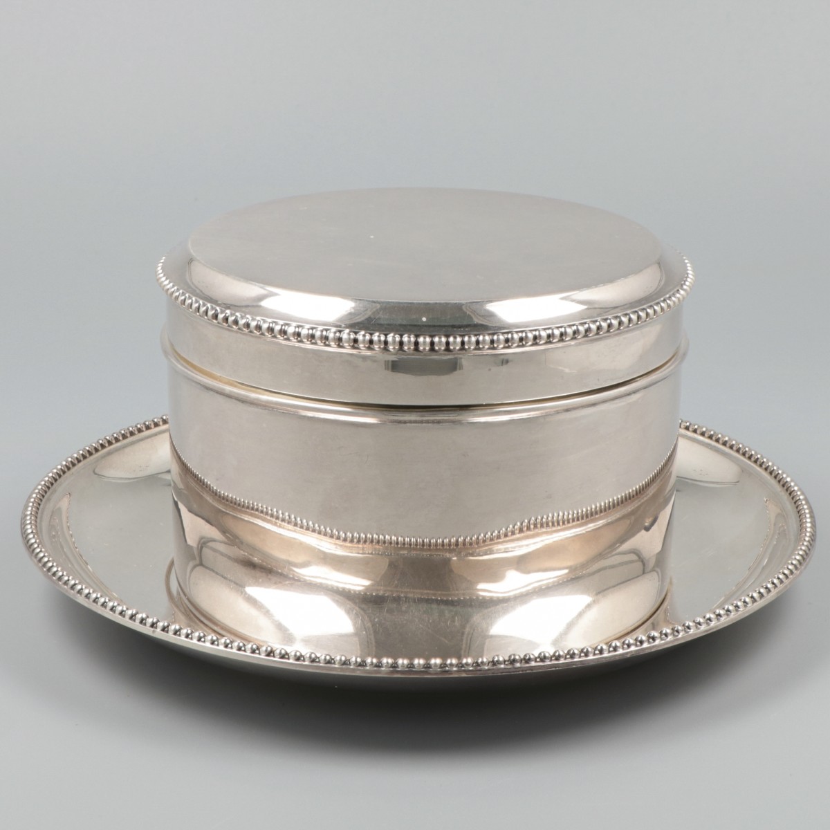 Koektrommel met onderschotel zilver.