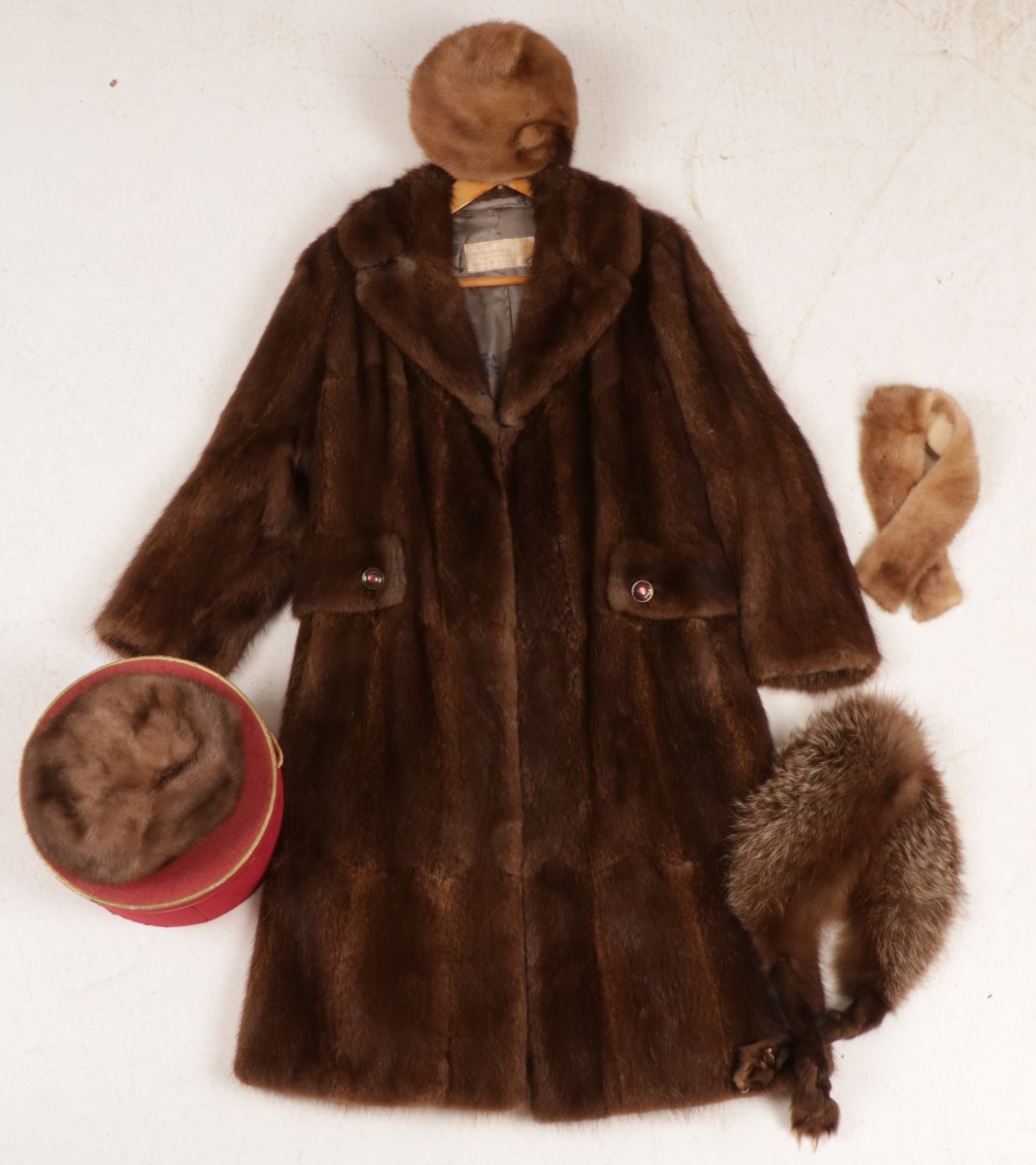 Een lot van diverse bont items, waaronder een mantel, stola en diverse mutsen.