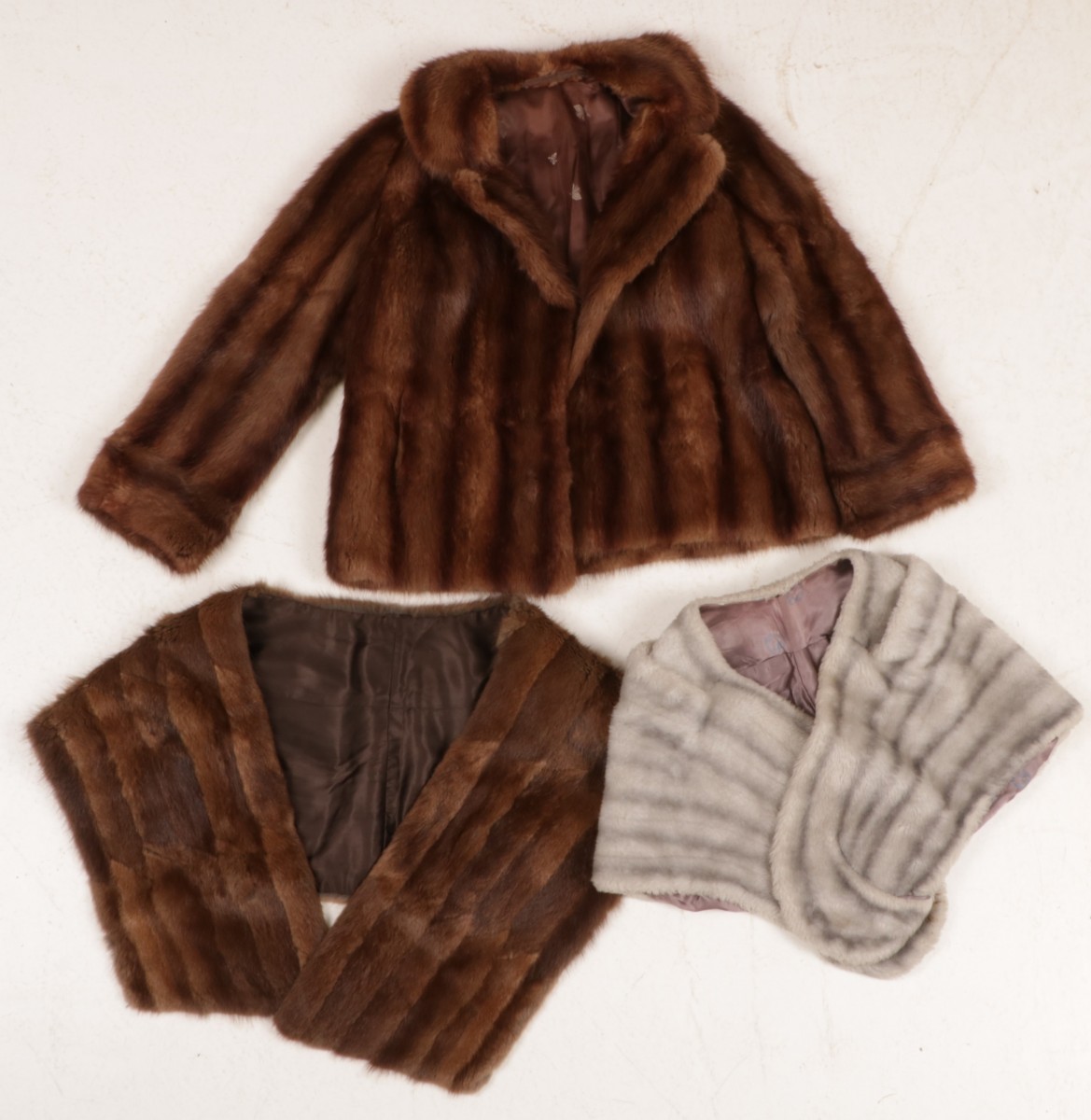 Een lot diverse nertsen bont items bestaande uit een korte jas en (2) stola's.