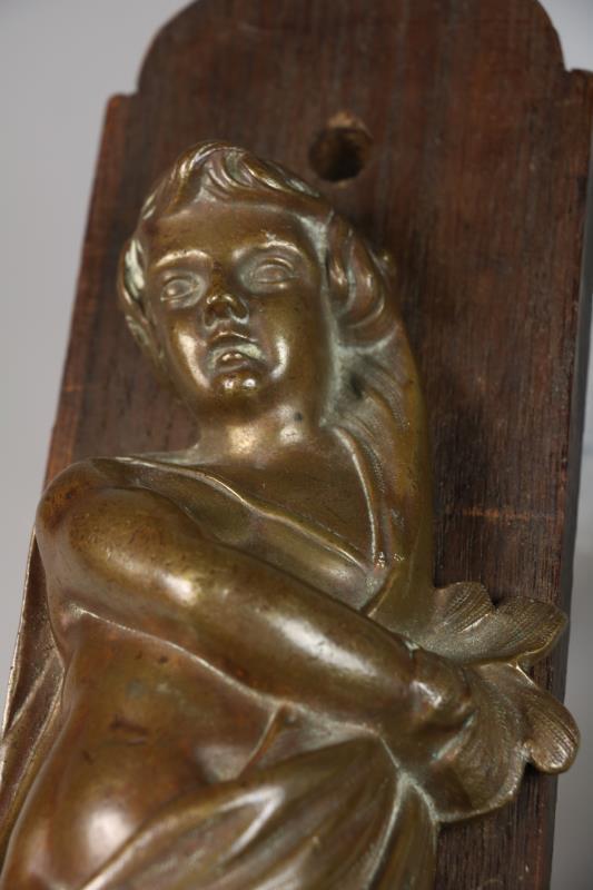 Twee bronzen putti, gemonteerd op paneeltjes, 1e helft 20e eeuw.