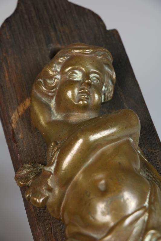 Twee bronzen putti, gemonteerd op paneeltjes, 1e helft 20e eeuw.