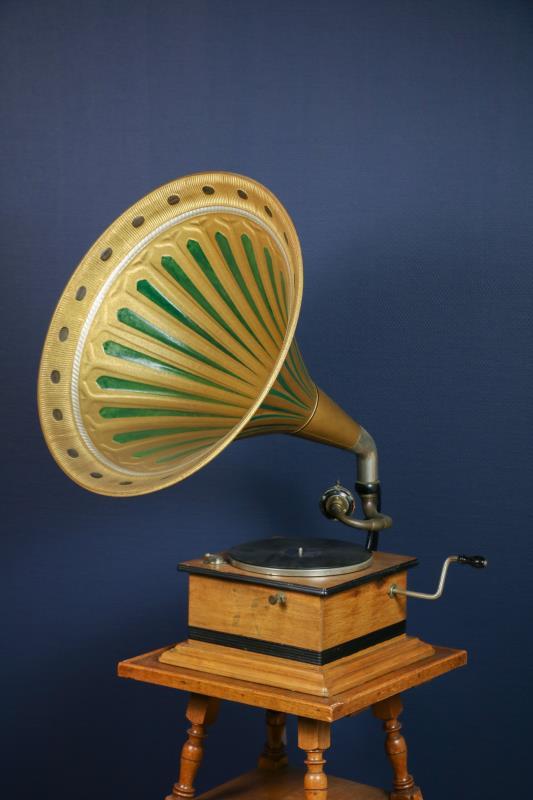 Een grammofoon met hoorn, in eiken behuizing, 1e helft 20e eeuw. Daarbij een eiken tafeltje.