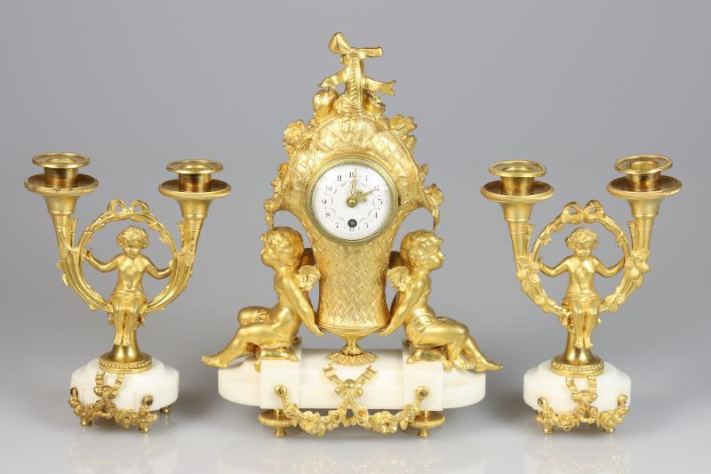 Een verguld bronzen Louis XVI stijl schouwpendule met twee bijpassende kandelabers. Frankrijk, laat 19e eeuw.