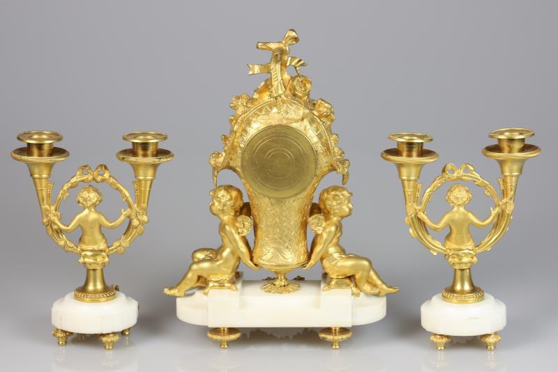 Een verguld bronzen Louis XVI stijl schouwpendule met twee bijpassende kandelabers. Frankrijk, laat 19e eeuw.