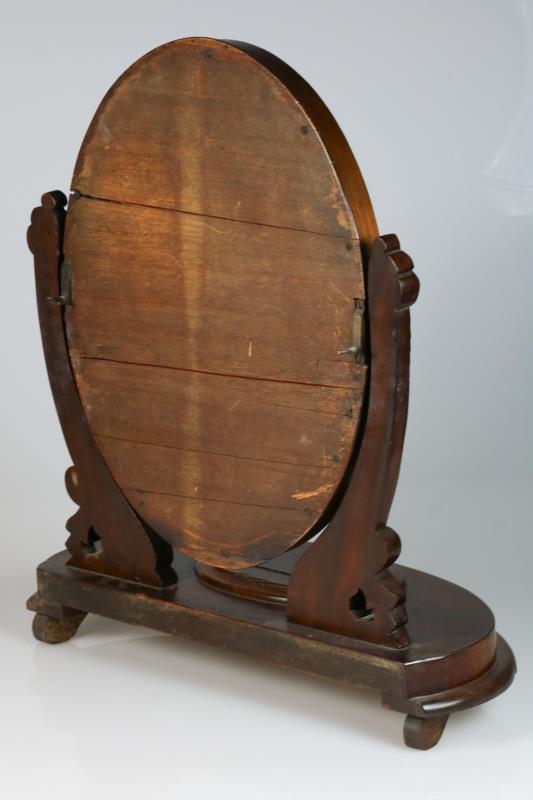 Een mahoniehouten kaptafel spiegel met snijwerk op standaard met opberg compartiment. 