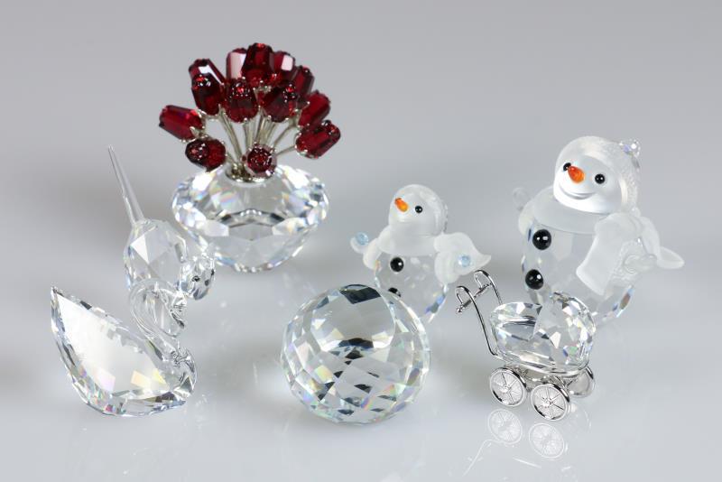 (7) delig lot divers Swarovski, 20e eeuw. Waaronder een bos rode rozen, een zwaan en kleine sneeuwpop (incl. cert.), een grote sneeuwpop, kinderwagen, kat en daarbij een presse papier. Allen inclusief dozen.