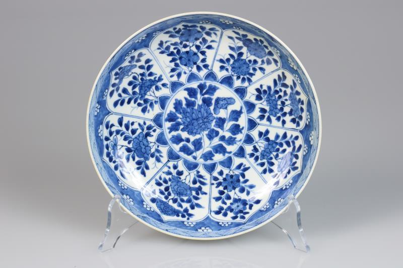 Een porseleinen bord met floraal decor in vakverdeling, gemerkt met een wierrookbrander. China, Kangxi.