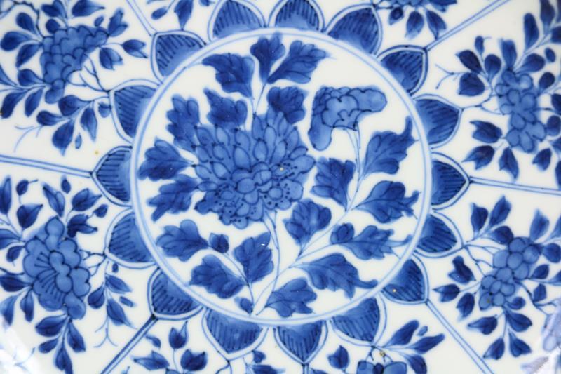 Een porseleinen bord met floraal decor in vakverdeling, gemerkt met een wierrookbrander. China, Kangxi.