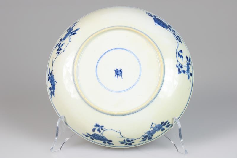Een porseleinen bord met floraal decor in vakverdeling, gemerkt met een wierrookbrander. China, Kangxi.