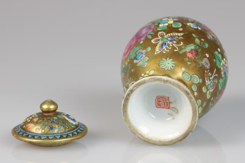 Een porseleinen theebus met floraal decor van vlinder en gouden fondkleur. China, 18e eeuw.