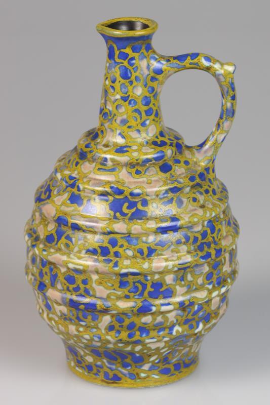 Een platelen schenkkan met floraal decor, gemerkt Rembrandt pottery Holland. Begin 20e eeuw.