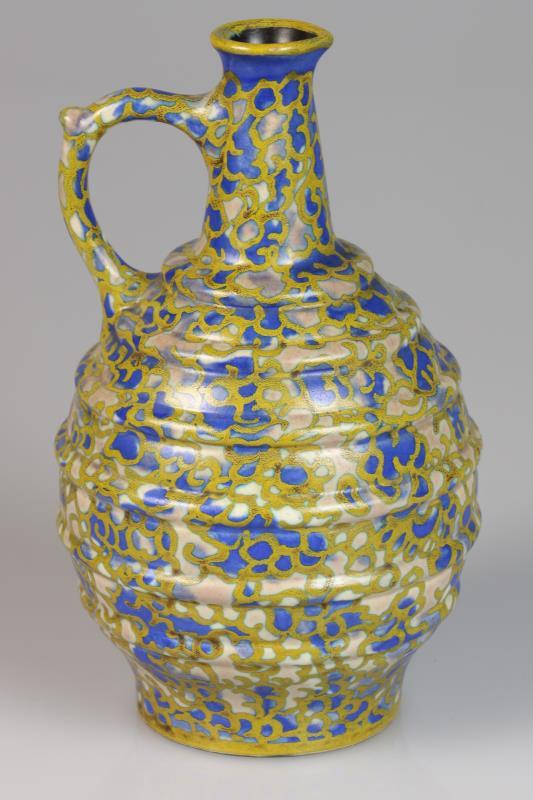 Een platelen schenkkan met floraal decor, gemerkt Rembrandt pottery Holland. Begin 20e eeuw.