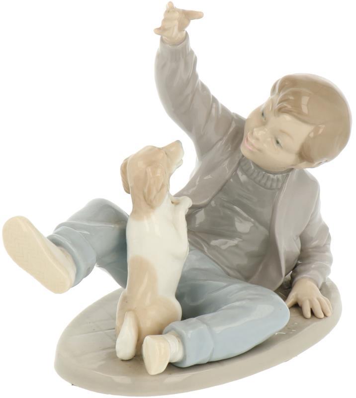 Een porseleinen groepje van een jongen met een hond. Nao, 2e helft 20e eeuw.