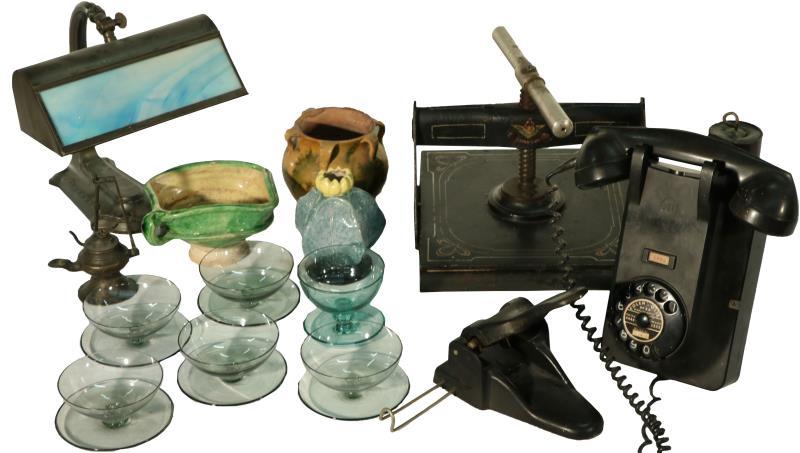 Een groot divers lot met o.a. gietijzeren boekenpers, een bakelieten wandtelefoon, een bureaulamp en divers glaswerk. Ca. 1920