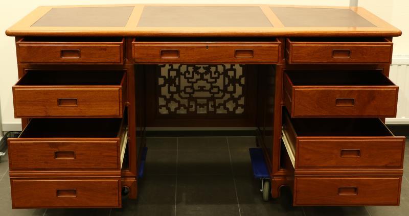 Een mahoniehouten bureau met bordeaux lederen inleg.