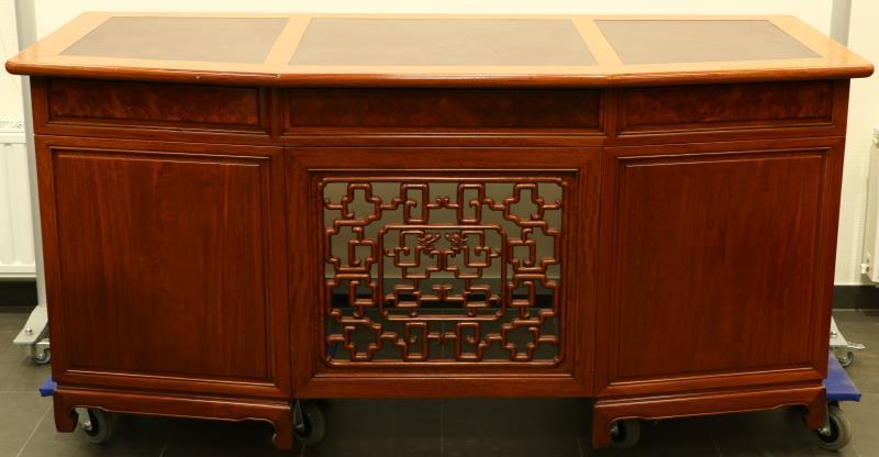 Een mahoniehouten bureau met bordeaux lederen inleg.
