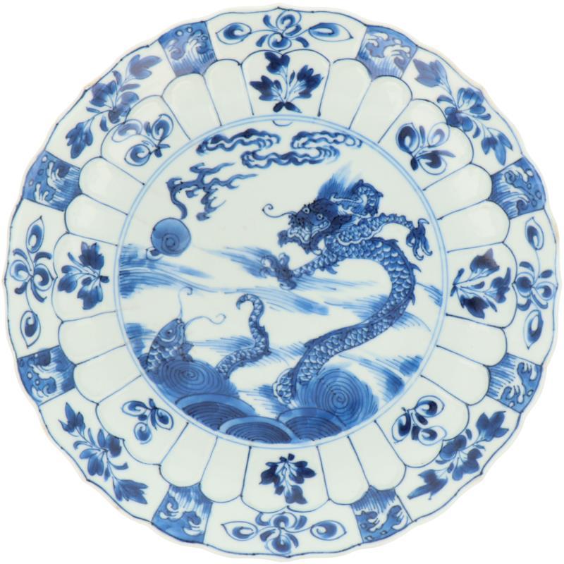 Een porseleinen bord met draken en karper decor, geschulpte rand, gemerkt met Lucky symbool. China, Kangxi.