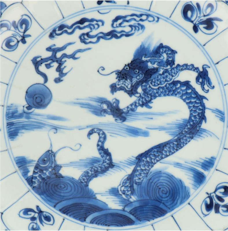 Een porseleinen bord met draken en karper decor, geschulpte rand, gemerkt met Lucky symbool. China, Kangxi.