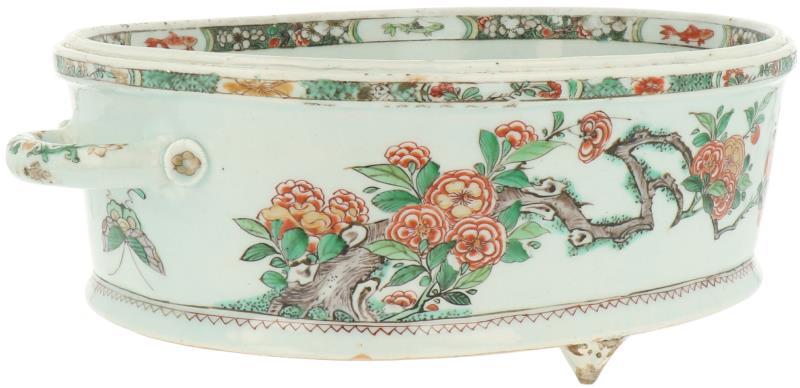 Een Famille Verte porseleinen jardinière gezet op drie voetjes met twee handvatten. China, Kangxi (circa 1700).