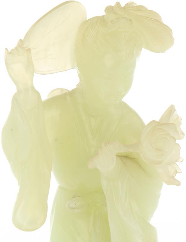 Een in jade vervaardigd figuur in de vorm van een Chinese vrouw met waaier en bloem, incl. sokkel. China, 19e/20e eeuw.