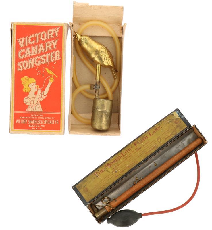 Een lot van drie camera's bestaande uit een "Victory Canary Songster" U.S.A - ca. 1920, een Rubberen "Bulb Shutter" - ca. 1960, en een The "Spred-Lite" Flash lamp - ca. 1910.