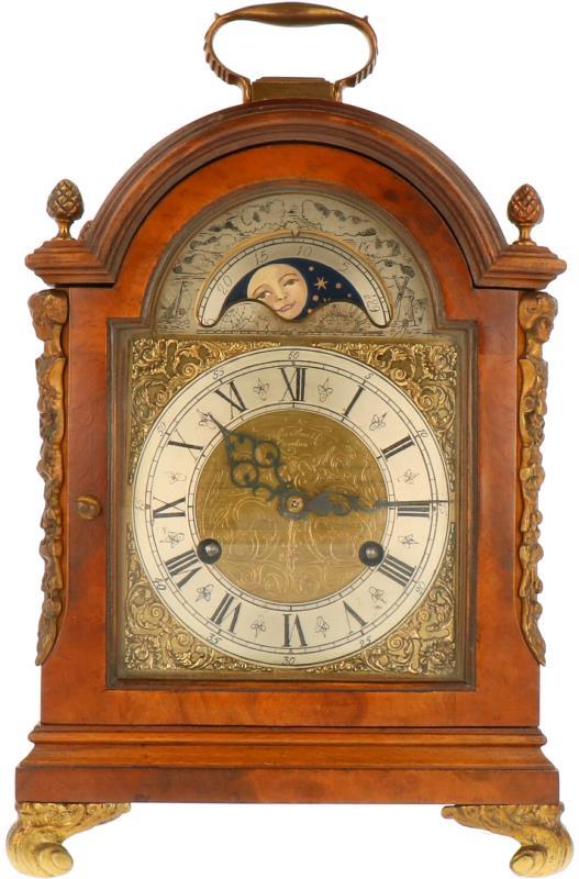 Een houten tafelklok met bronzen ornamenten. Midden 20e eeuw.
