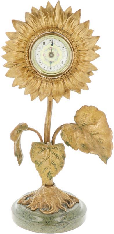 Een bronzen klokje met emaille wijzerplaat in de vorm van een zonnebloem. Frankrijk, eind 19e eeuw.
