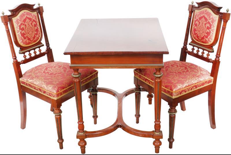 Een tête-à-tête bestaande uit twee stoelen en een tafeltje naar 19e eeuws model. Gefineerd met mahonie en versierd met messing ornamenten.