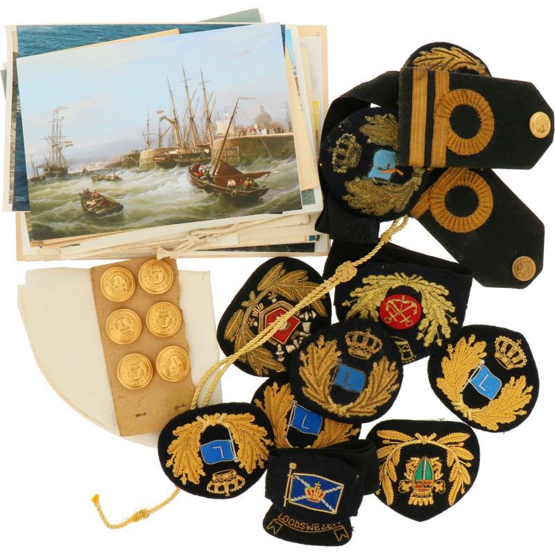 Een lot militaria met onder anderen insignes, epauletten, knopen en ansichtkaarten.