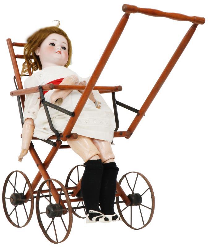 Een poppenwagen met pop. Circa 1900.