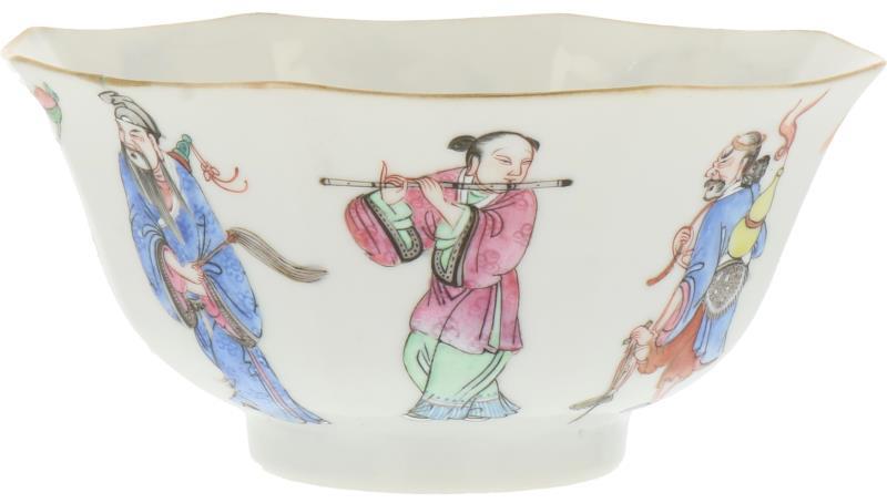Een porseleinen kom afgebeeld met Chinese figuren en aan de binnenzijde perzikken. China, circa 1900.