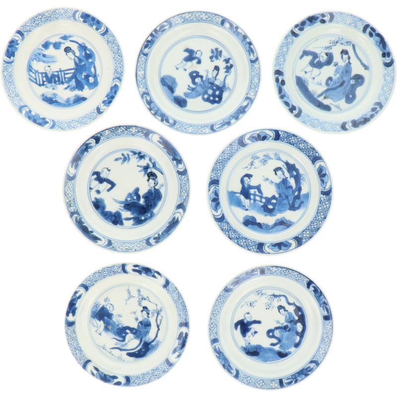 Een lot van zeven porseleinen bordjes met decor van Lingzhi's en spelende Zotjes. China, Kangxi