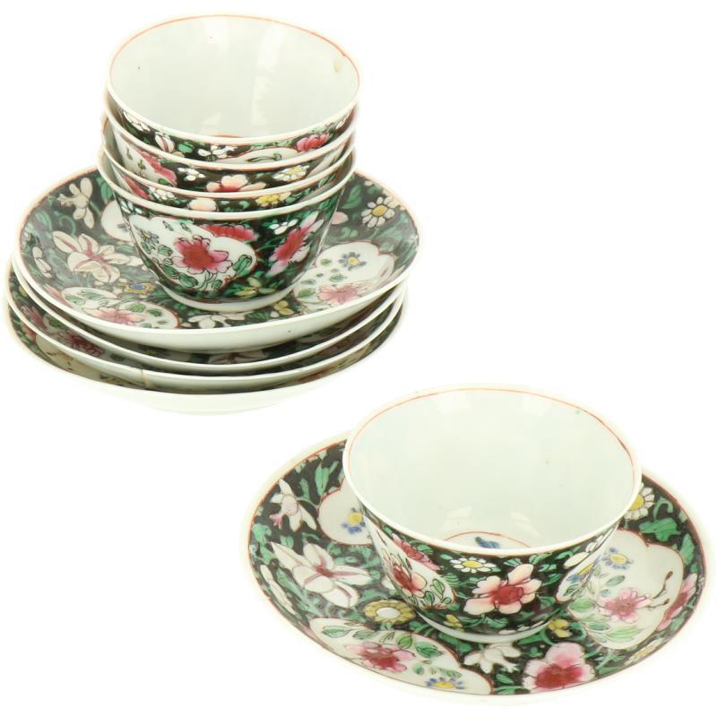 Een lot van vijf porseleinen kop en schotels met famille noir decor. China, 18e eeuw.