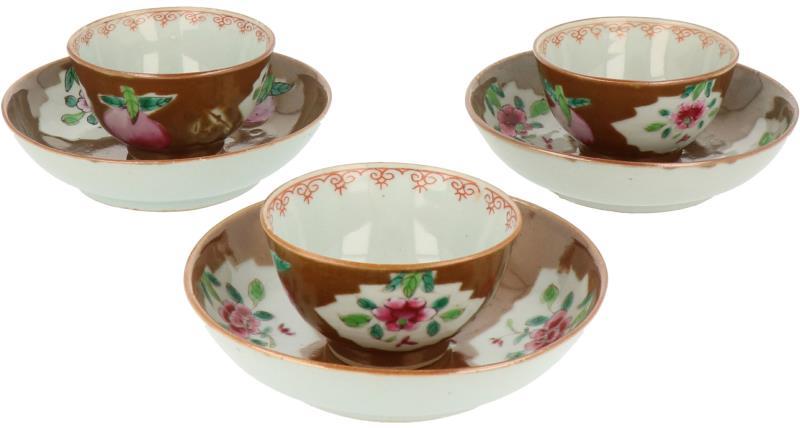 Een set van drie porseleinen kop en schotels met capucijner decor.