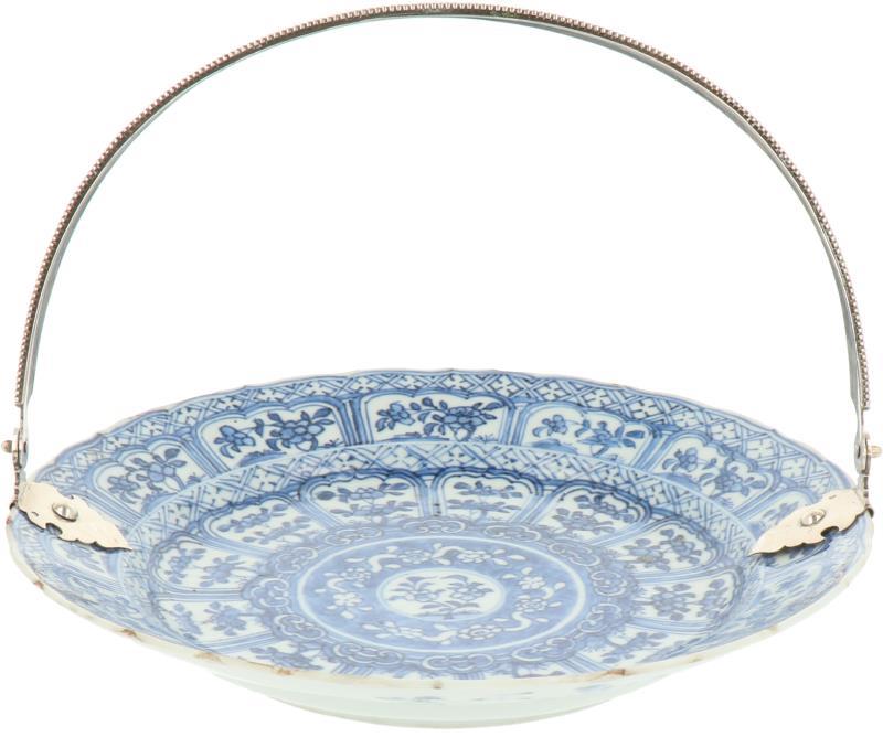 Een porseleinen bord met blauw bloemendecor in vakverdeling, met zilveren hengsel handvat. China, 18e eeuw.