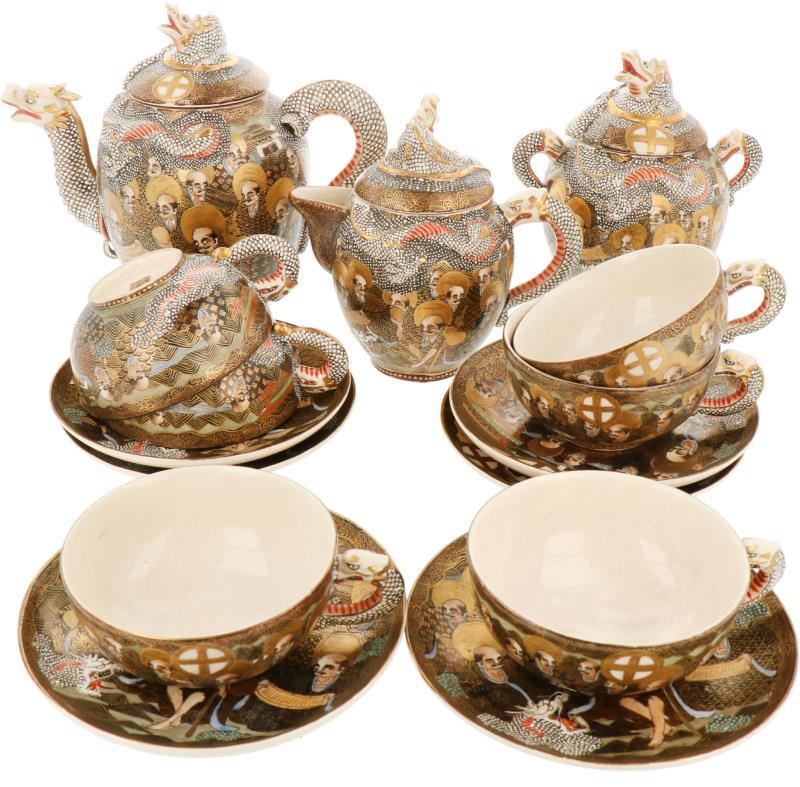 Een servies van satsuma aardewerk bestaande uit een theepot, roomstel en zes kop en schotels. Japan, 1e helft 20e eeuw.