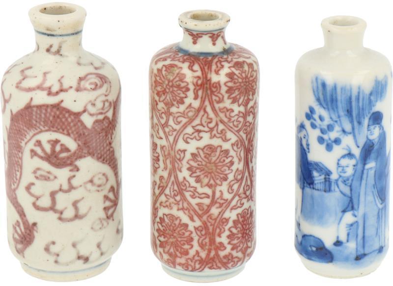 Een lot van drie porseleinen snuff bottles w.o. twee met 'iron red' decor. China, 19e eeuw.