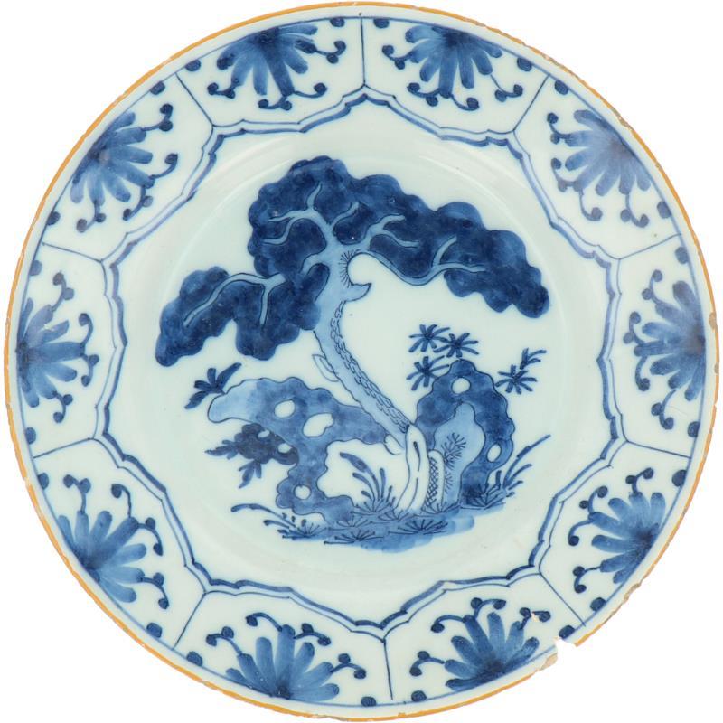 Een aardewerk bord met landschaps decor, gemerkt De Porceleyne Byl. Delft, 18e eeuw.