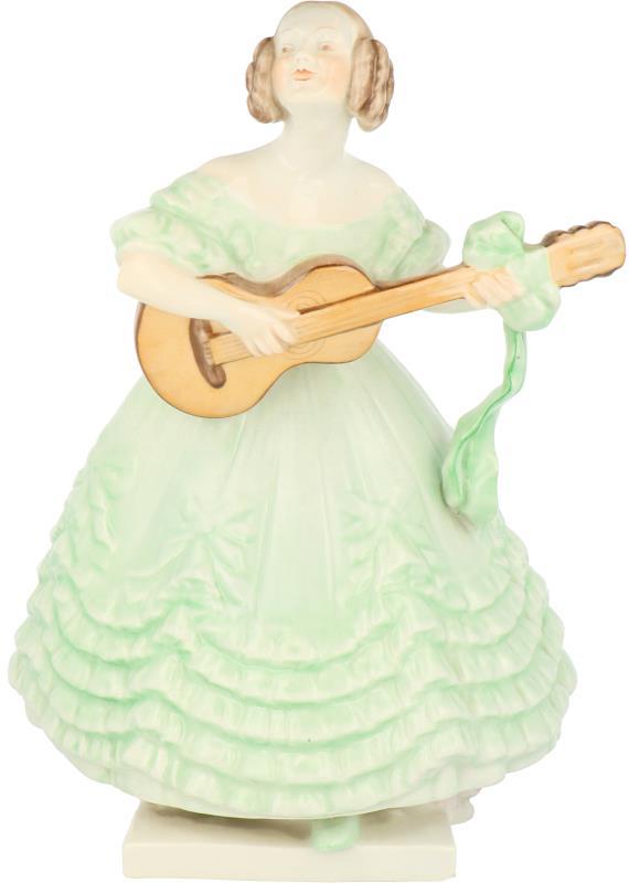 Een porseleinen beeld in de vorm van een gitaar spelende dame. Herend Hongarije, eind 20e eeuw.