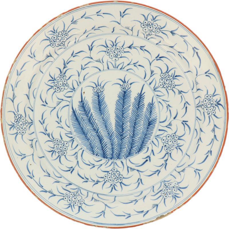 Een aardewerk schotel met bloemen decor. Ca. 1800.