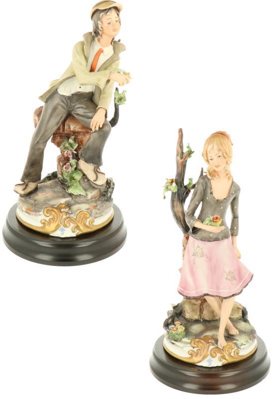 Een stel van twee aardewerk beelden van een jongen en een meisje, gemerkt Capodimonte. Italië, eind 20e eeuw.