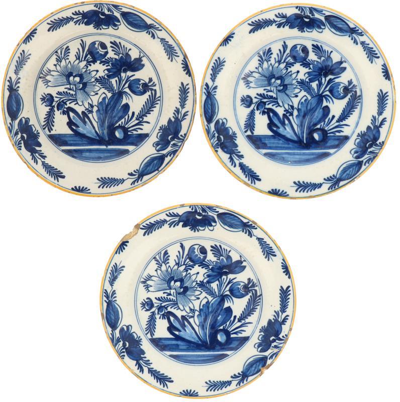 Een set van drie aardewerk borden met bloemdecor. Delft, 18e eeuw.