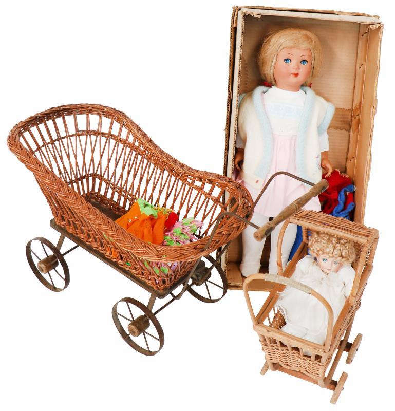 Een kavel met poppen, benodigdheden en poppenwagens. Eén in de doos en één in de wagen met daarbij een losse poppenwagen.