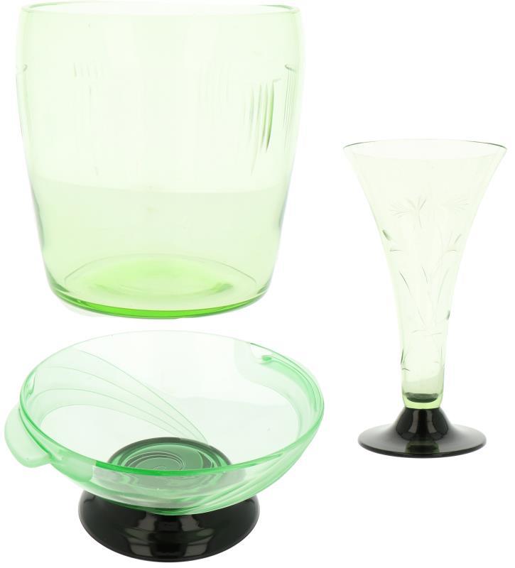 Een lot van drie diverse glazen objecten w.o. een schaal op voet en twee bloemenvazen, vervaardigd in uranium of annaglas. 