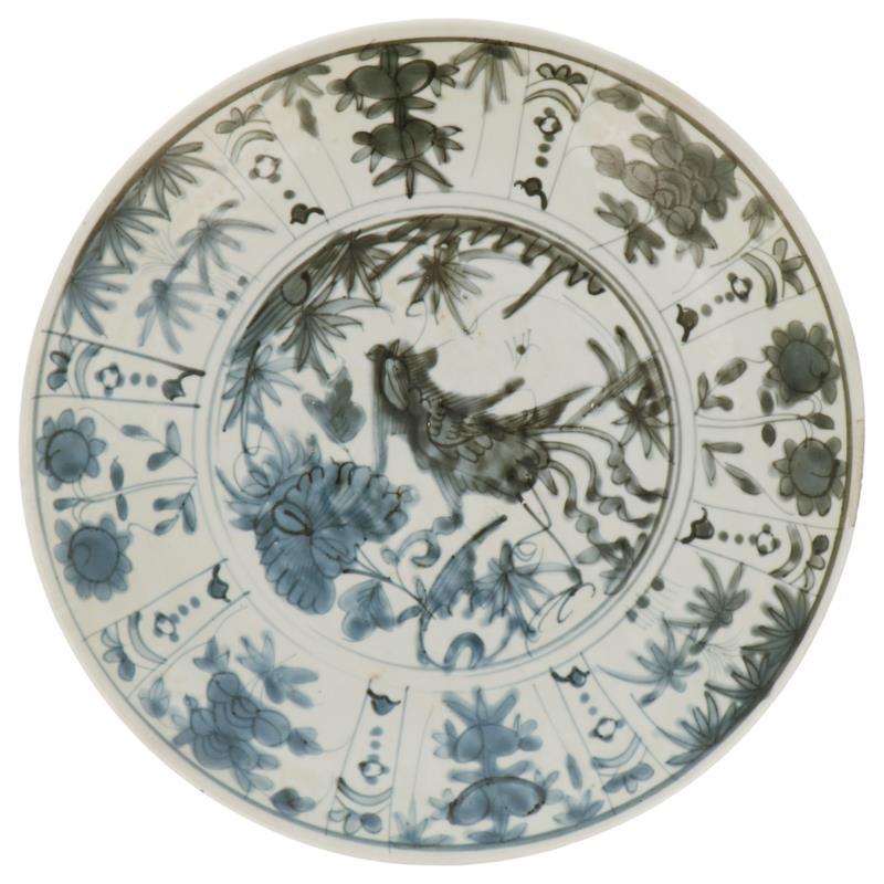 Een porseleinen schotel met onder andere bloemendecor in vakverdeling. China, Ming.