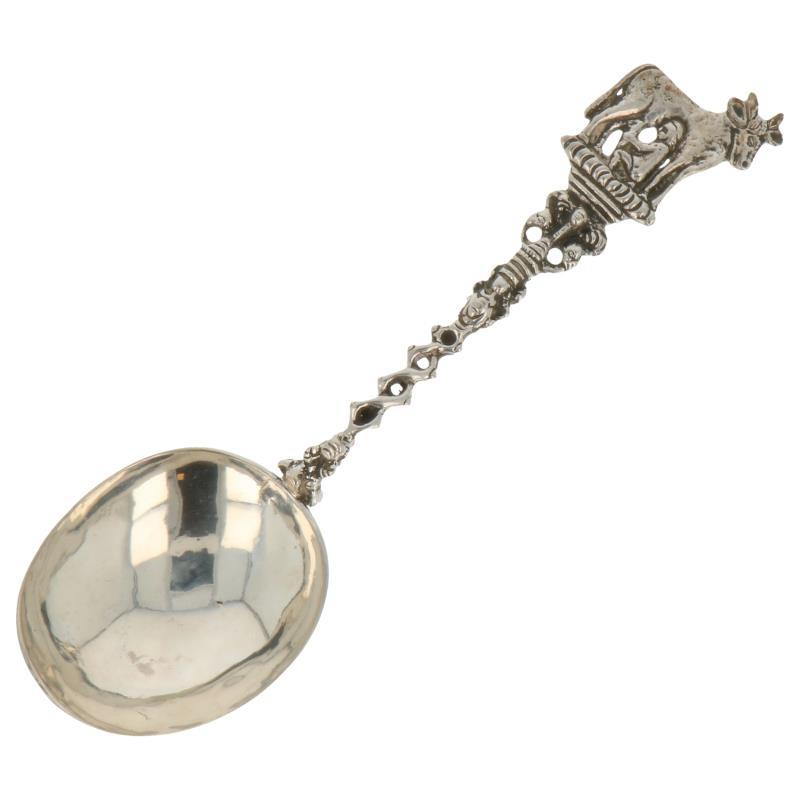 Gelegenheids lepel met gevlochten steel en afgebeelde koeienmelker zilver.