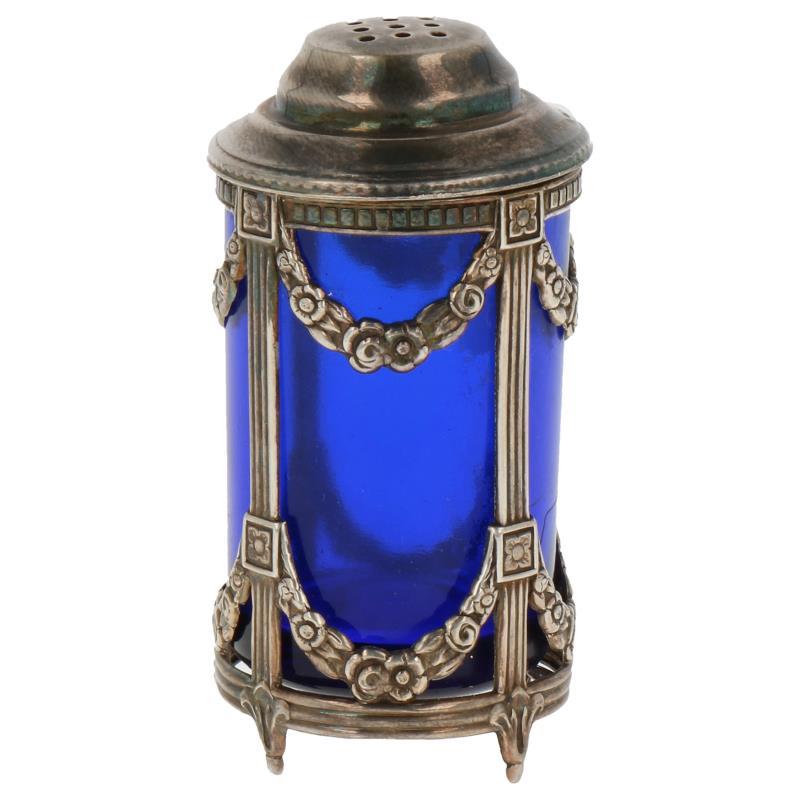 Zoutstrooier met blauwglazen inzet voorzien van neo gotische versieringen zilver.