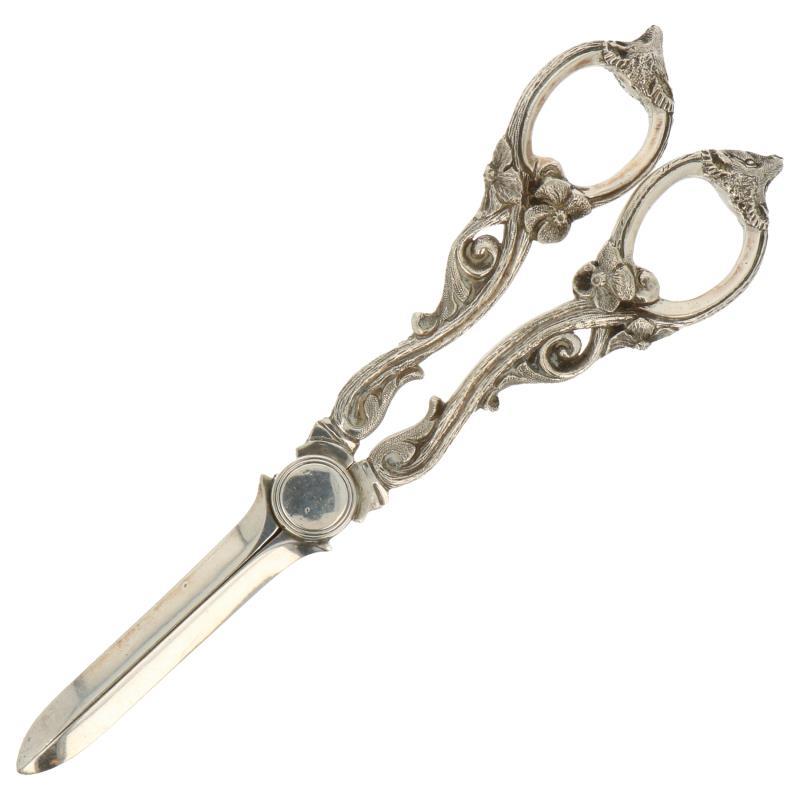 Tafelschaartje waarschijnlijk voor lonten versierd met bloemranken en vossenkoppen zilver.