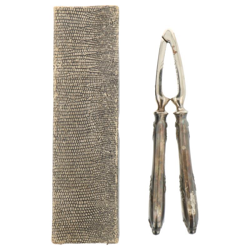 Notenkraker met rocailles gedecoreerde handvatten zilver.